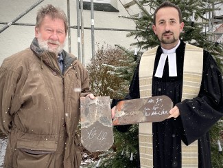 Vertrauensmann Gerlach und Pfarrer Fischer mit zwei ganz besonderen Ziegeln